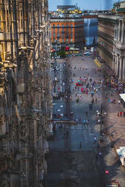 People walk on brown near historic buildings during the day
